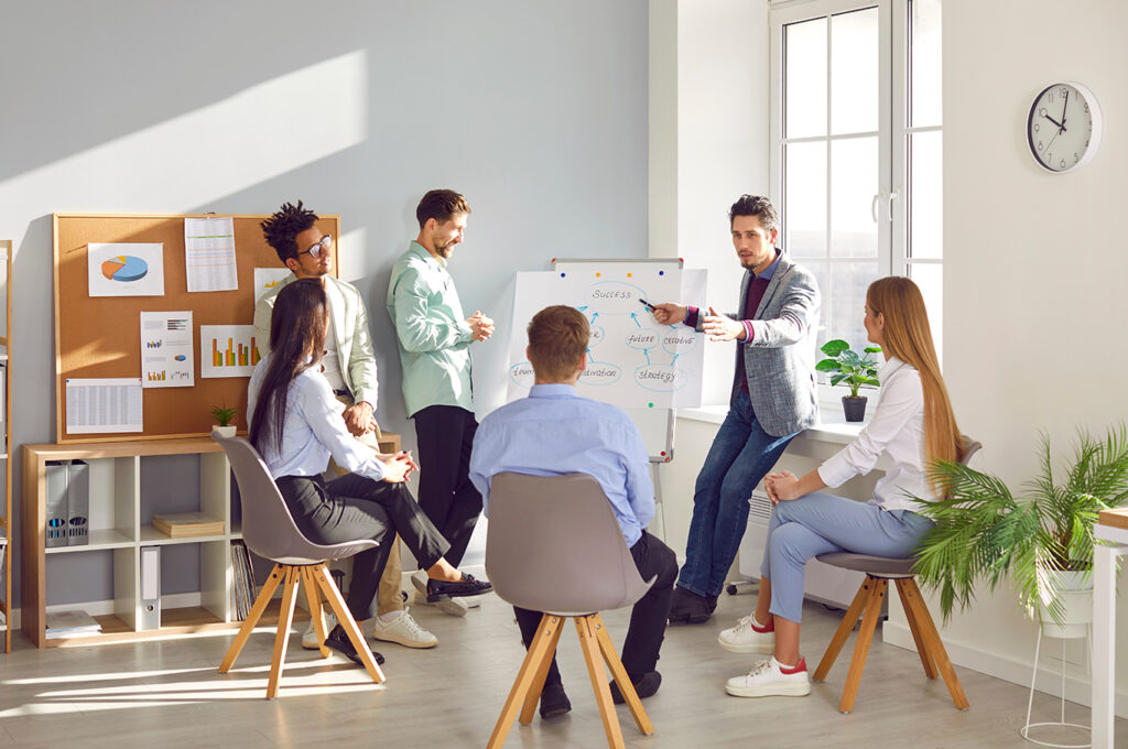Business trainer leading an interactive group facilitation session in a modern office setting